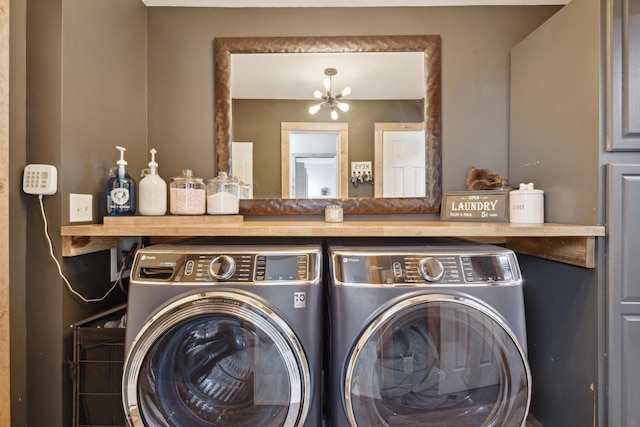 clothes washing area featuring laundry area, a notable chandelier, and independent washer and dryer