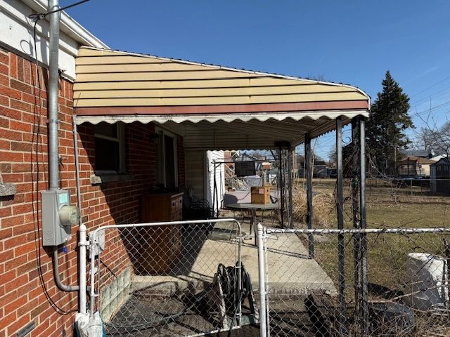 exterior space featuring a carport, a gate, and fence