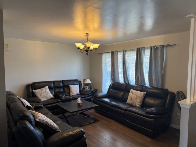 living room with a notable chandelier and wood finished floors