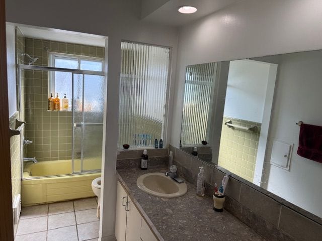 full bathroom featuring enclosed tub / shower combo, toilet, vanity, and tile patterned flooring