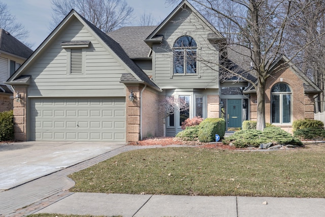 view of front of house with concrete driveway, a front yard, a shingled roof, a garage, and brick siding