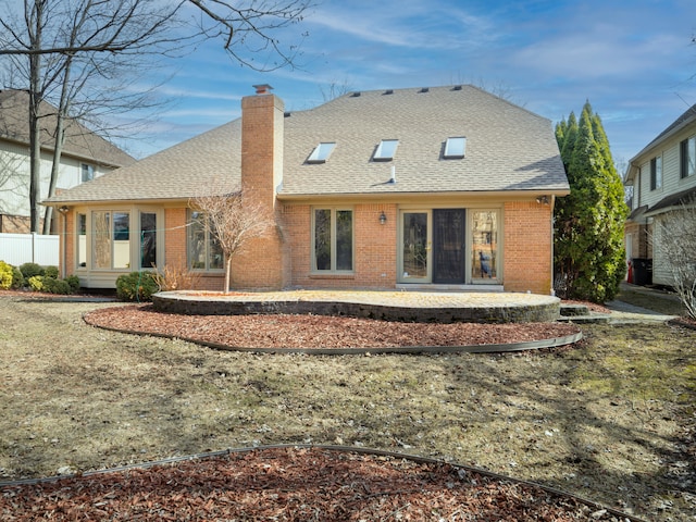 rear view of house featuring a shingled roof, brick siding, and a chimney