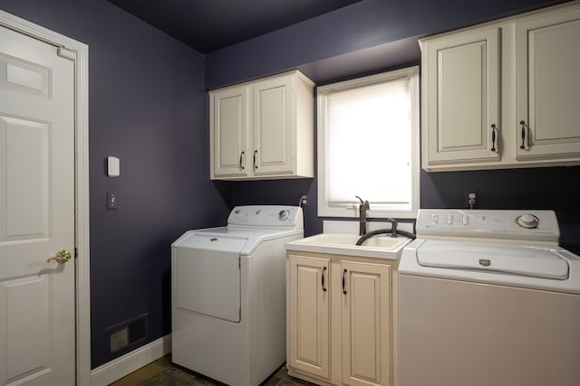 laundry area featuring visible vents, baseboards, washer and dryer, cabinet space, and a sink