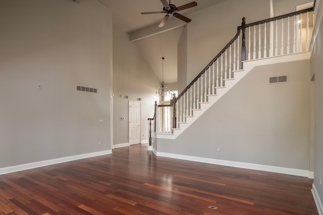 interior space with wood finished floors, stairway, ceiling fan with notable chandelier, and visible vents