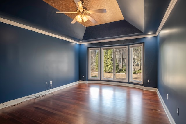 spare room with baseboards, a raised ceiling, wood finished floors, and crown molding