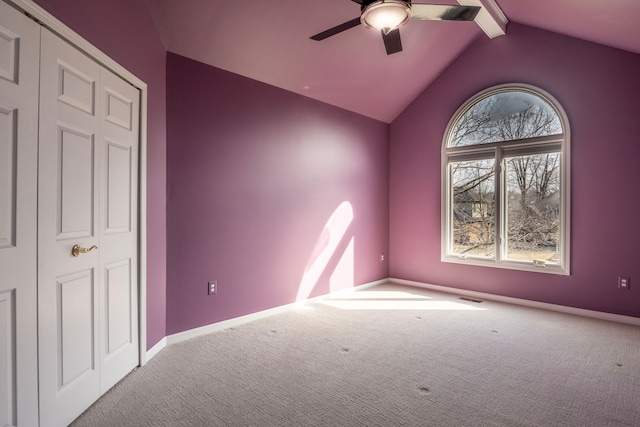 carpeted empty room with vaulted ceiling with beams, visible vents, baseboards, and ceiling fan