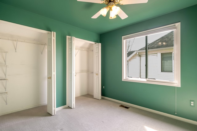 unfurnished bedroom with baseboards, carpet floors, visible vents, and ceiling fan