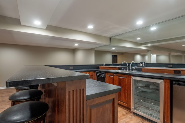 bar with wet bar, beverage cooler, light wood-style floors, and a sink