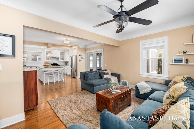 living area featuring a wealth of natural light, visible vents, and light wood-type flooring