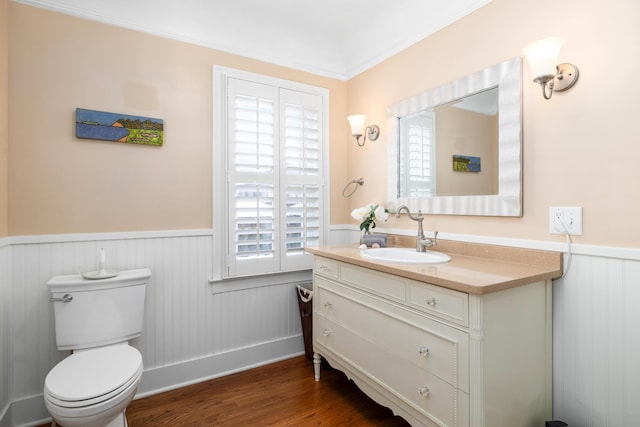 bathroom with wainscoting, vanity, toilet, and wood finished floors