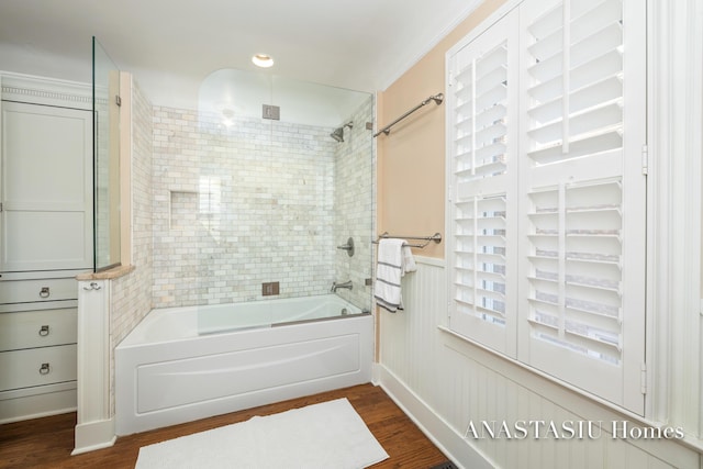 bathroom featuring wainscoting, bathtub / shower combination, and wood finished floors