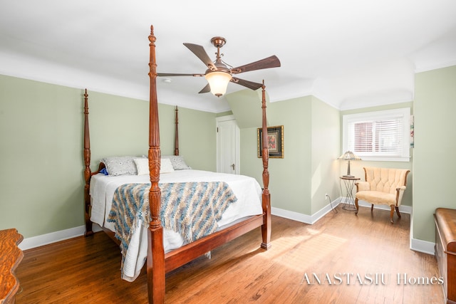 bedroom featuring ceiling fan, baseboards, wood finished floors, and ornamental molding