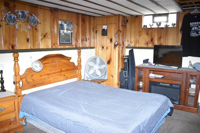 carpeted bedroom featuring wooden walls