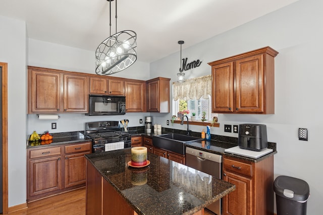 511 State St, Oxford, MI 48371 - kitchen featuring black appliances, a sink, brown cabinetry, light wood-style flooring, and pendant lighting