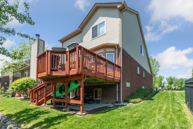 511 State St, Oxford, MI 48371 - rear view of house featuring brick siding, a wooden deck, and a yard