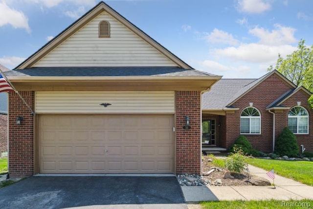 511 State St, Oxford, MI 48371 - view of front facade with brick siding, driveway, roof with shingles, and an attached garage