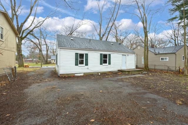 20450 Midway Ave, Southfield, MI 48075 - rear view of house featuring driveway, roof with shingles, and fence