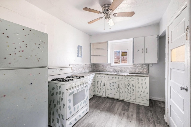 kitchen featuring white range with gas cooktop, a ceiling fan, a sink, tasteful backsplash, and wood finished floors