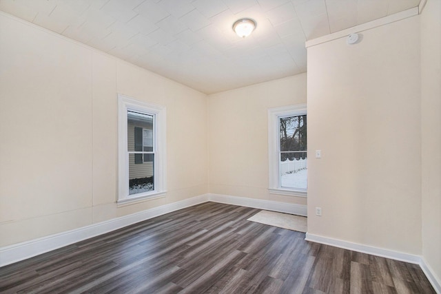 empty room with baseboards and dark wood finished floors