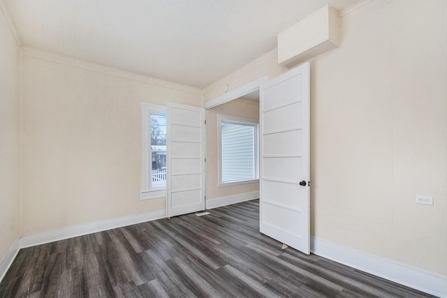spare room with dark wood-style floors, baseboards, and ornamental molding