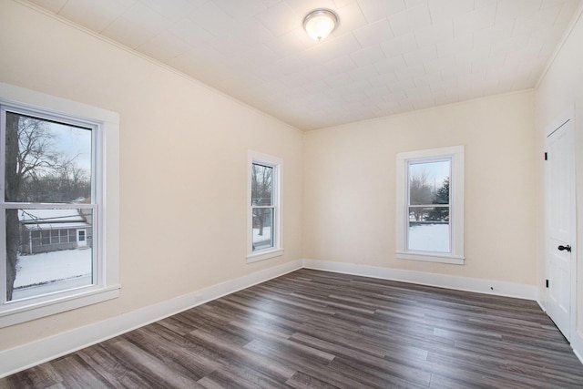 unfurnished room featuring baseboards, dark wood-style floors, and crown molding