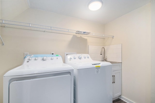 washroom with baseboards, wood finished floors, cabinet space, independent washer and dryer, and a sink