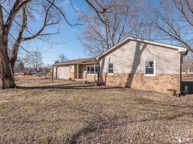 view of property exterior featuring brick siding and a garage