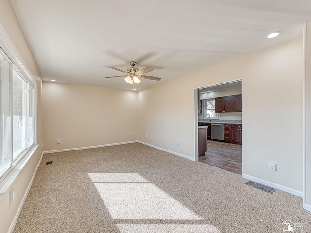 unfurnished room featuring visible vents, baseboards, a ceiling fan, and carpet flooring