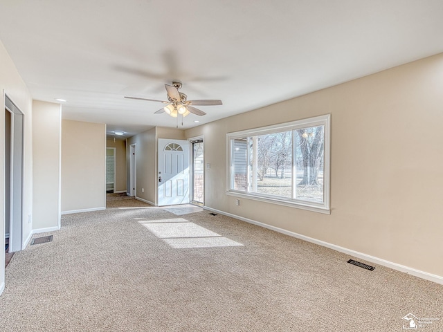 unfurnished room with visible vents, baseboards, carpet, and ceiling fan