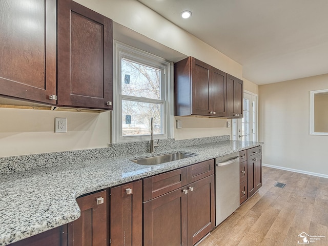 kitchen with light stone counters, a sink, dark brown cabinetry, light wood-style floors, and dishwasher