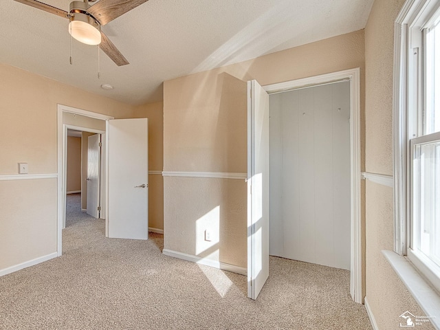 interior space with carpet flooring and ceiling fan