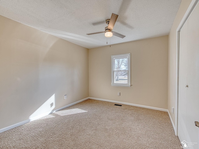 spare room featuring visible vents, baseboards, carpet, and a ceiling fan