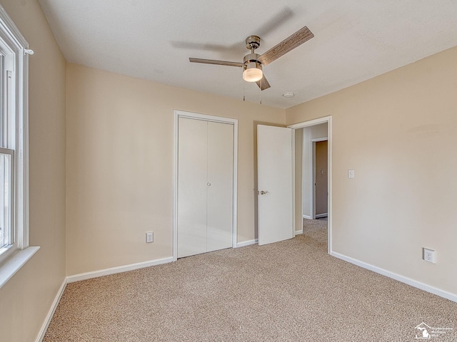 unfurnished bedroom featuring a closet, baseboards, carpet, and a ceiling fan