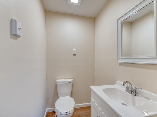 bathroom featuring vanity, toilet, and baseboards