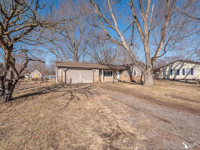 single story home with a garage, brick siding, and driveway