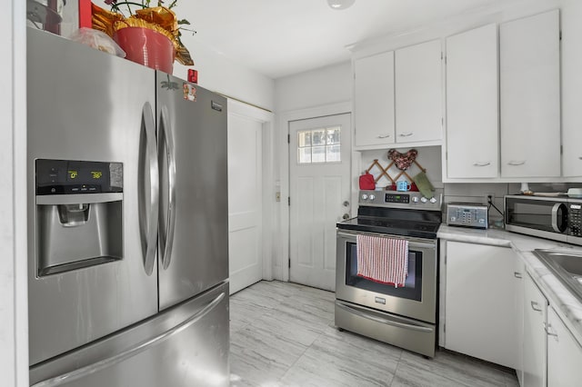 kitchen featuring a sink, light countertops, white cabinets, and stainless steel appliances