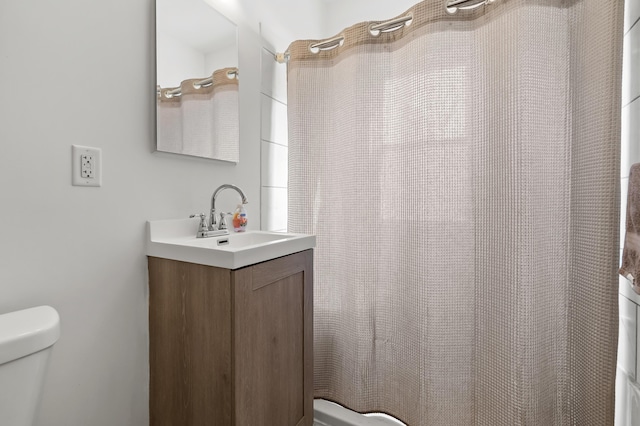 bathroom with vanity, curtained shower, and toilet