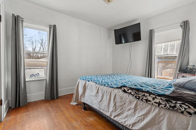 bedroom with light wood-type flooring and baseboards