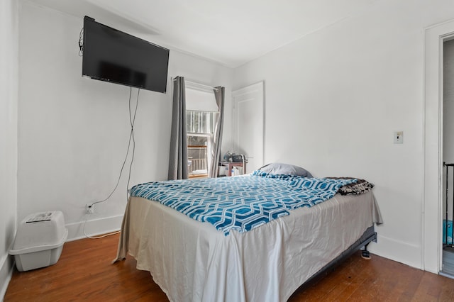 bedroom featuring wood finished floors and baseboards