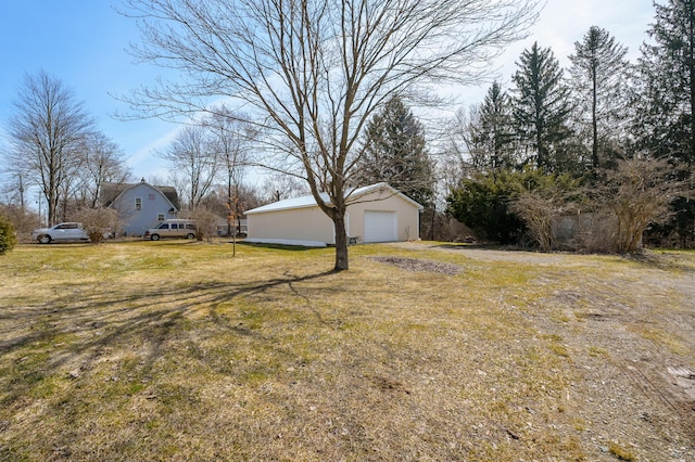 view of yard with a detached garage and an outdoor structure