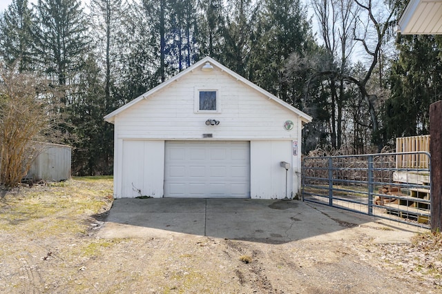 detached garage with fence and driveway