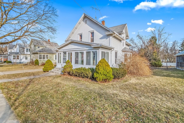 view of front of property with a front yard and a chimney