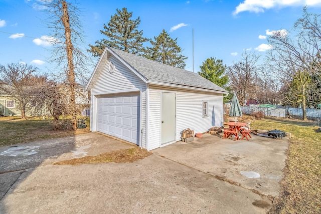 detached garage featuring fence