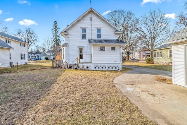 back of property with a residential view, a yard, and fence