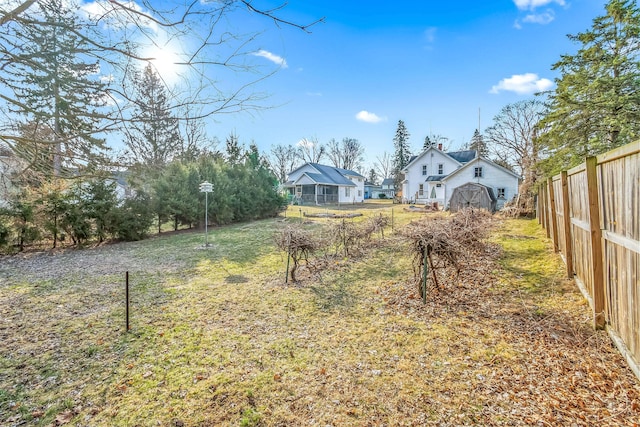 view of yard featuring an outbuilding, a storage shed, and fence