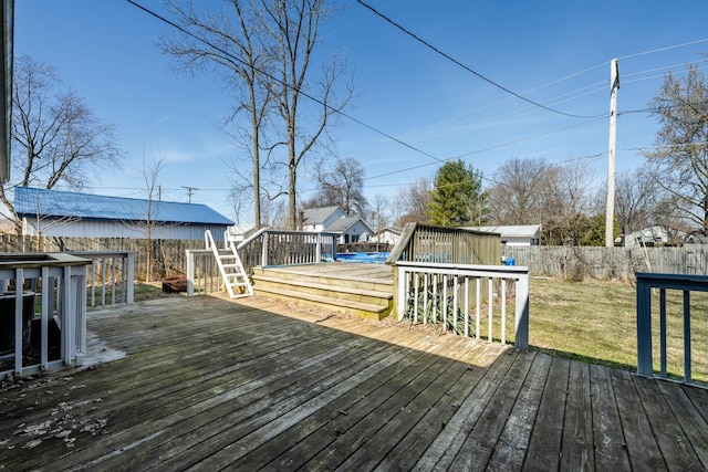 wooden terrace with a yard and a fenced backyard