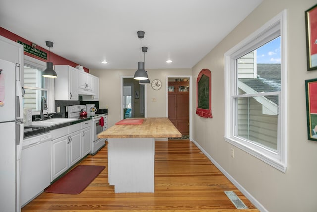 kitchen featuring visible vents, butcher block counters, light wood-style flooring, white appliances, and white cabinetry