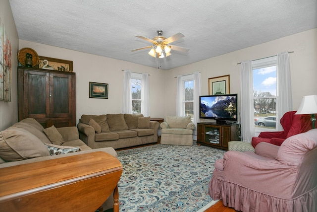 living room featuring a textured ceiling and a ceiling fan