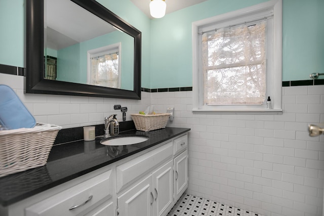 bathroom with vanity, tile walls, tile patterned flooring, and wainscoting