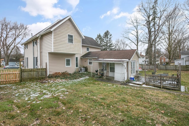 back of property featuring a deck, central air condition unit, a yard, and fence